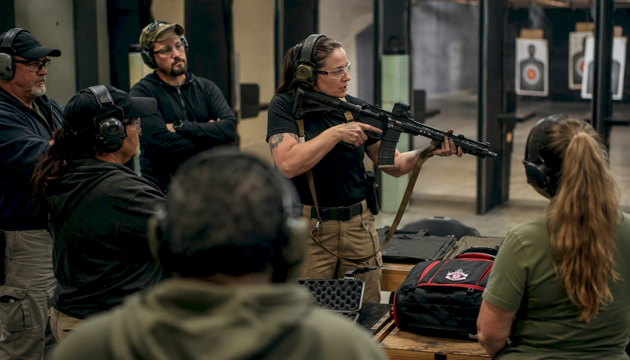 Instructor teaching firearm safety at indoor shooting range