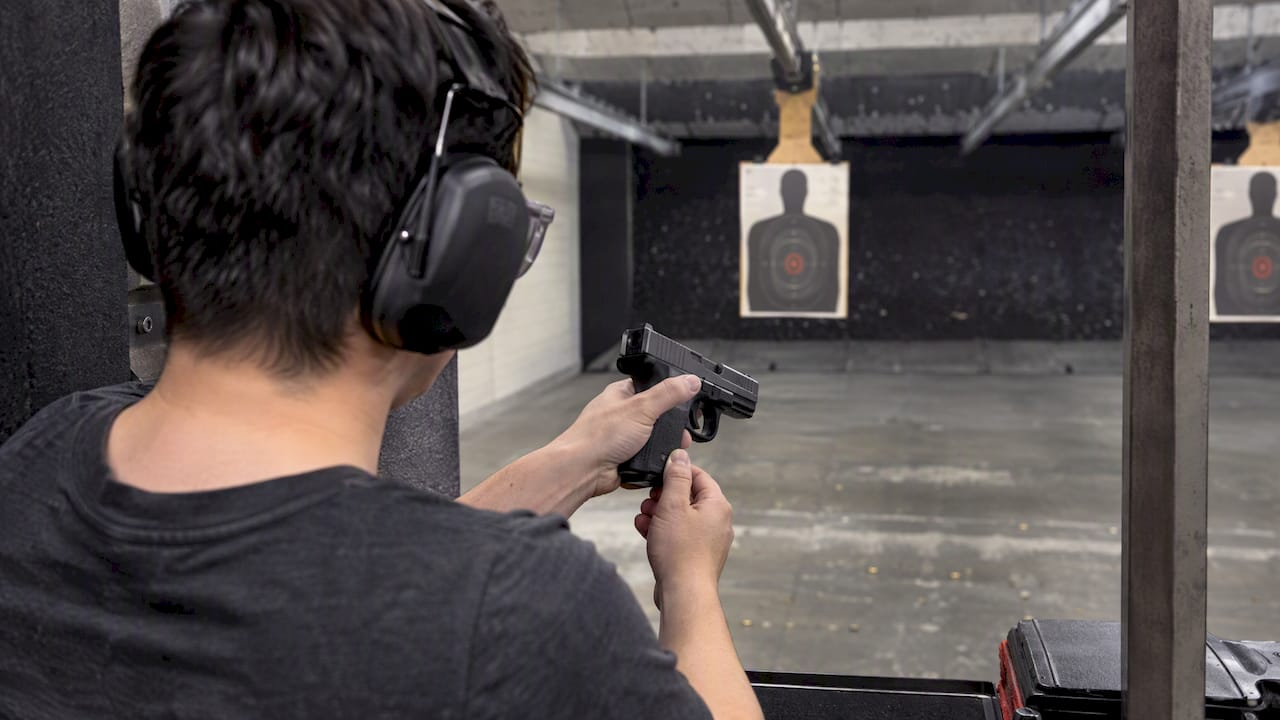 Left-handed shooter checking pistol grip reach